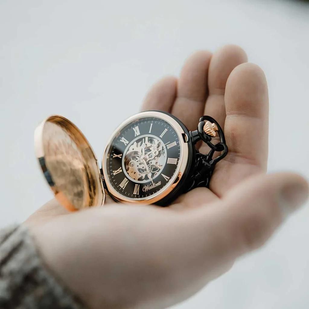 Drevené vreckové hodinky Waidzeit Skelett Gold & Black v ruke – detailný pohľad na mechanický ciferník a elegantné orechové drevo